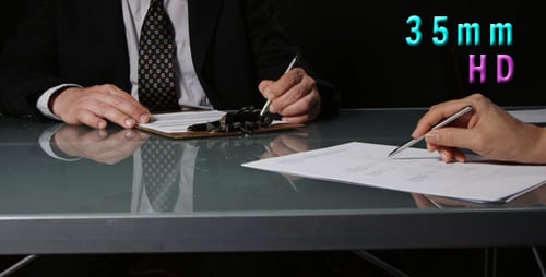 People Signing Business Agreement at a Table