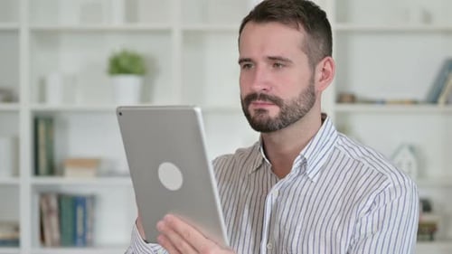 Adult Man Works On Tablet At Home