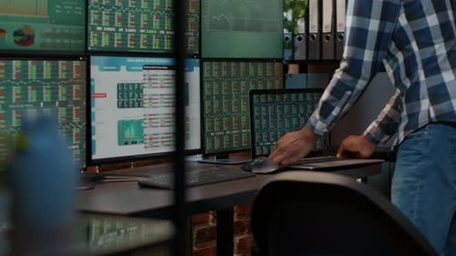 Hedge Fund Trader Analyzing Forex Market Numbers on Laptop