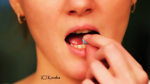 Young Adult Woman Taking Pill With Water