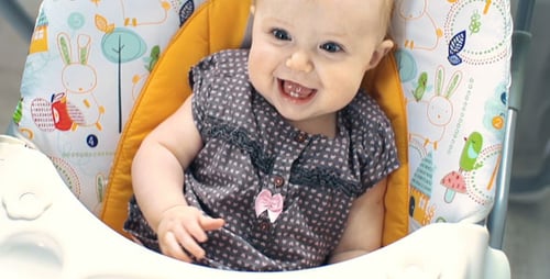 Adorable Infant Smiling and Laughing in Baby Chair
