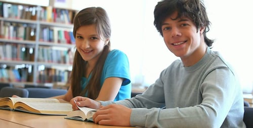 Boy and Girl Reading Books in Library