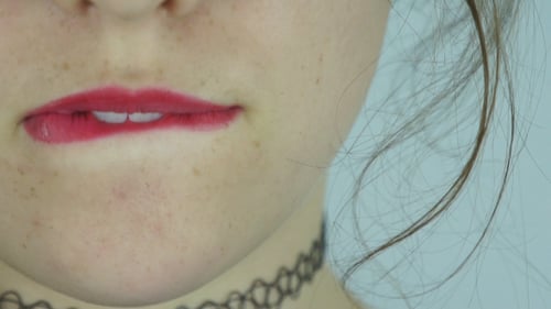 Woman Bites Lip With Red Lipstick Close Up