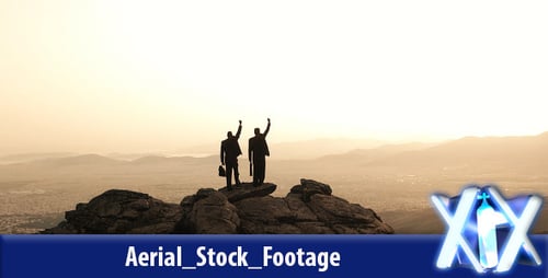 Men Celebrate Success Atop Mountain Overlooking City