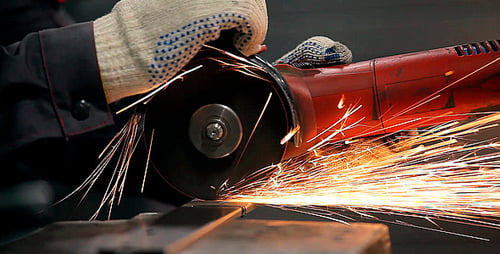 Gloved Hand Cutting Metal With Angle Grinder