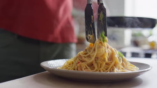 Steaming Spaghetti Placed onto Plate in Kitchen