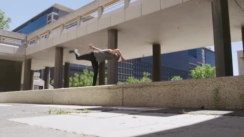 Young Man Performs Parkour Flip in Urban Setting