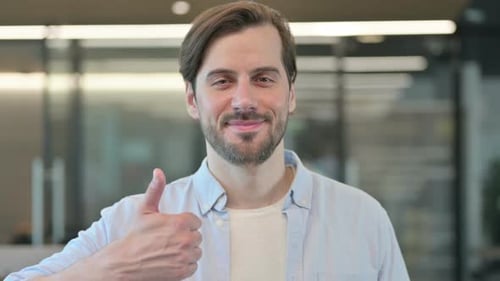 Smiling Man Gives Thumbs Up in Office Setting