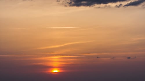 Vibrant Orange Sunset Clouds with Airplane Trails
