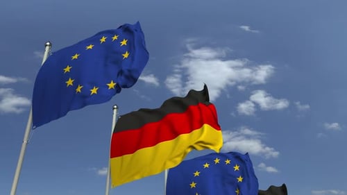 German and European Union Flags Waving Against Blue Sky