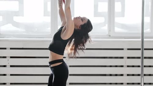 Graceful Woman Performing Aerial Hoop Gymnastics in Studio