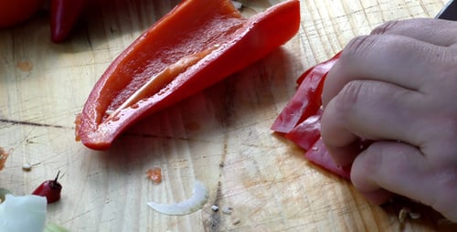 Person Chopping Red Pepper on Wooden Cutting Board