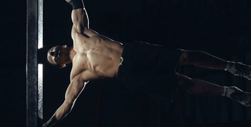 Muscular Man Performing Human Flag on Pole