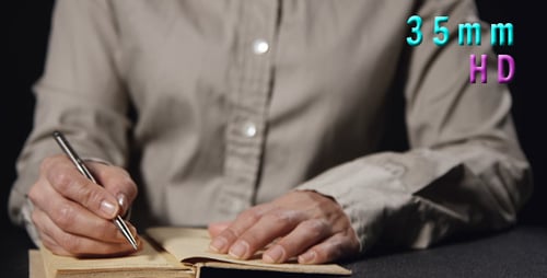 Person Writes in a Journal with Silver Pen
