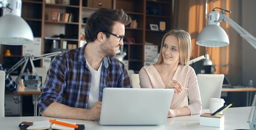Office Colleagues Collaborating On Laptop at Desk