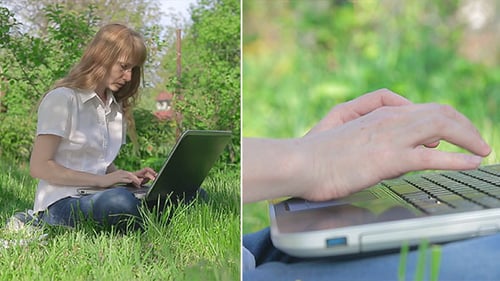 Woman Using Laptop While Sitting in Field