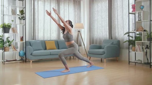 Woman Doing Yoga Exercises on Mat in Living Room