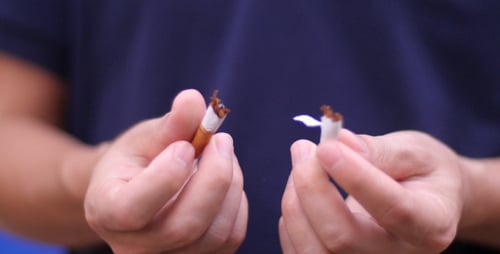 Mains humaines cassant la cigarette