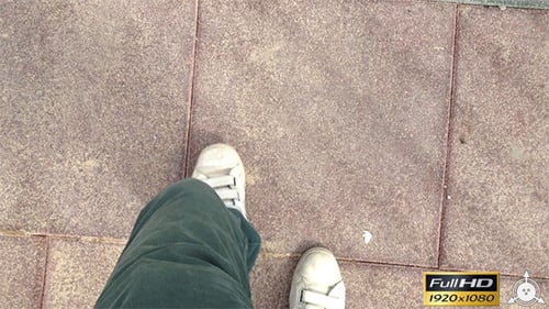 Foot in White Sneaker Walks on Tile Sidewalk