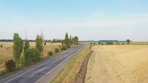 Aerial Shot of Electric Car Driving on Countryside Road. New Modern Vehicle Riding Fast Along
