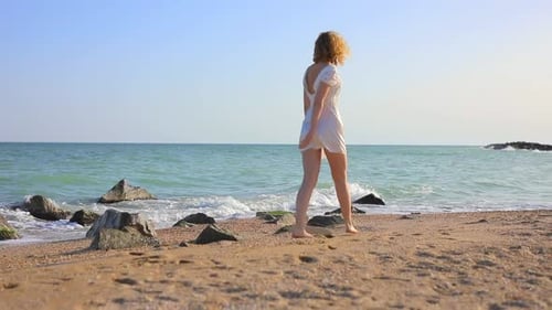 Young Beautiful Woman Walking at the Ocean Beach