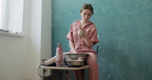 Woman Holding Ceramic Pot in Art Studio