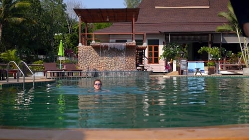 Young Fun Couple Jumping In Tropical Swimming Pool