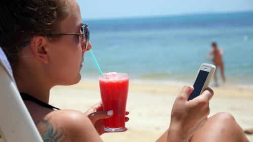 Young Woman Texting Message On Smartphone At Beach