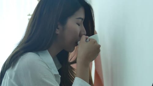 Woman Drinking from Cup in Bright Home Interior