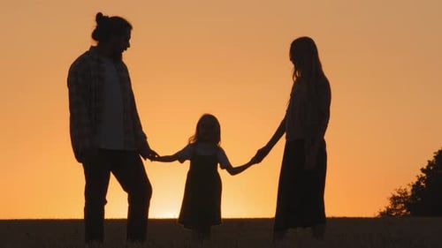 Family Silhouette in Field at Sunset