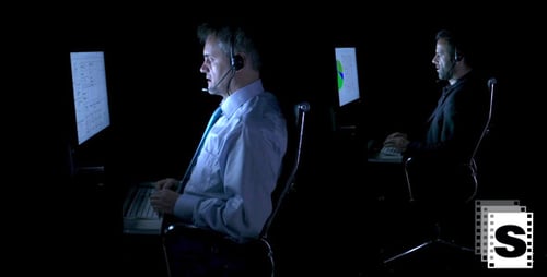 Two Men Work at Computers in Dark Office