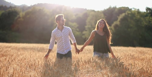 Couple amoureux qui traverse le champ de blé
