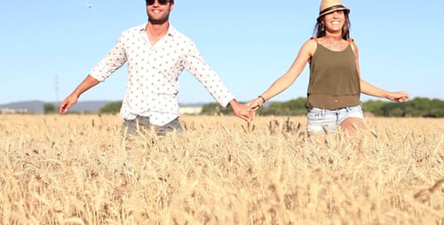 Happy Couple Runs Through Golden Wheat Field
