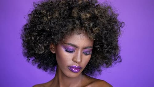 Glamorous Woman with Purple Makeup on Purple Background