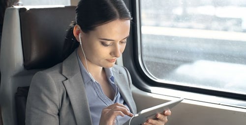Woman Uses Tablet on Train Commute