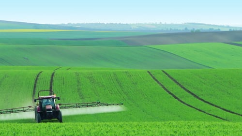 Traktor bewässern das Feld