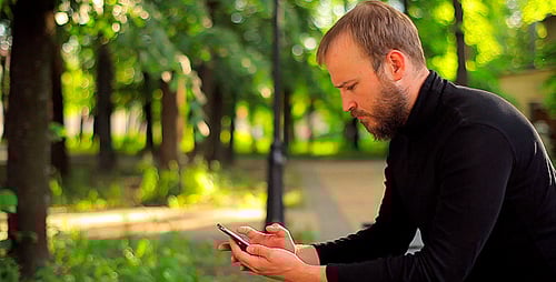 The Young Man With the Phone Sitting in the Park