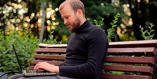 The Young Man Working on a Laptop in the Park
