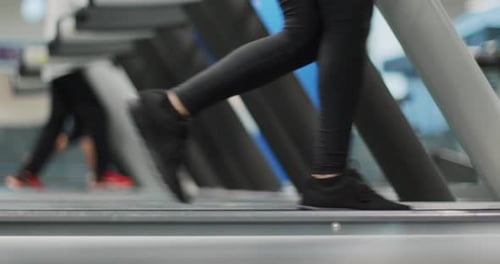 Young Woman Walking on a Treadmill at Gym