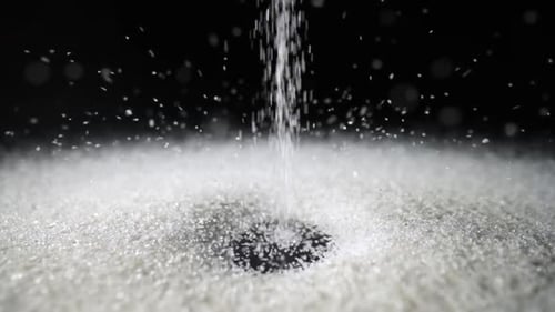 Particles of White Dry Sand Pour in Stream Hit the Surface and Scatter in Different Directions on an