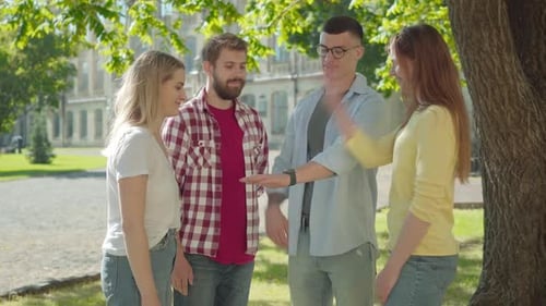 Young Friends Unite Hands in Sunny Park