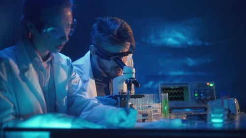 Scientists Working with Microscope in Laboratory