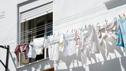 Infant Clothes Hanging on Clothesline Outside Home