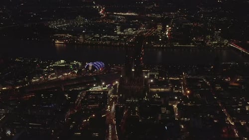 AERIAL: Beautiful Wide Shot Over Cologne Germany at Night Time with City Lights