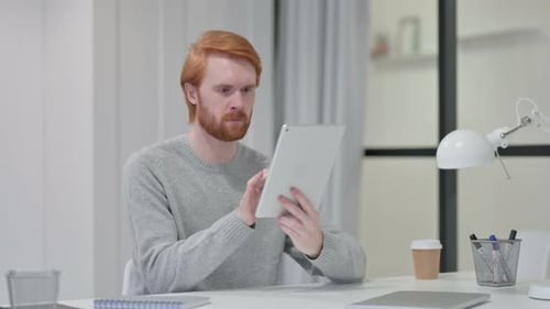 Young Adult Using Tablet at Desk Indoors