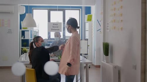 Dois colegas de trabalho tocando o cotovelo durante a pandemia global de coronavírus