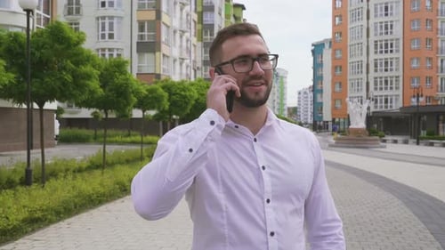 Man Talking on Phone Walking in City