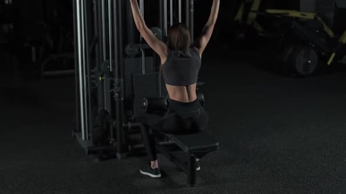 Female in the Gym Lifting Blocks on Rack Machine Back View Training on Block Device and Gym