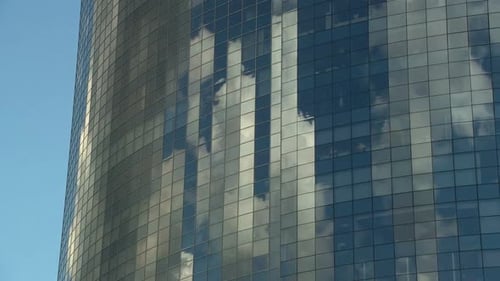Tall Mirrored Skyscraper Reflects the Clouds Going By in a Timelapse