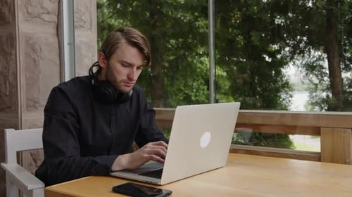 Young Adult Using Laptop at Table Indoors